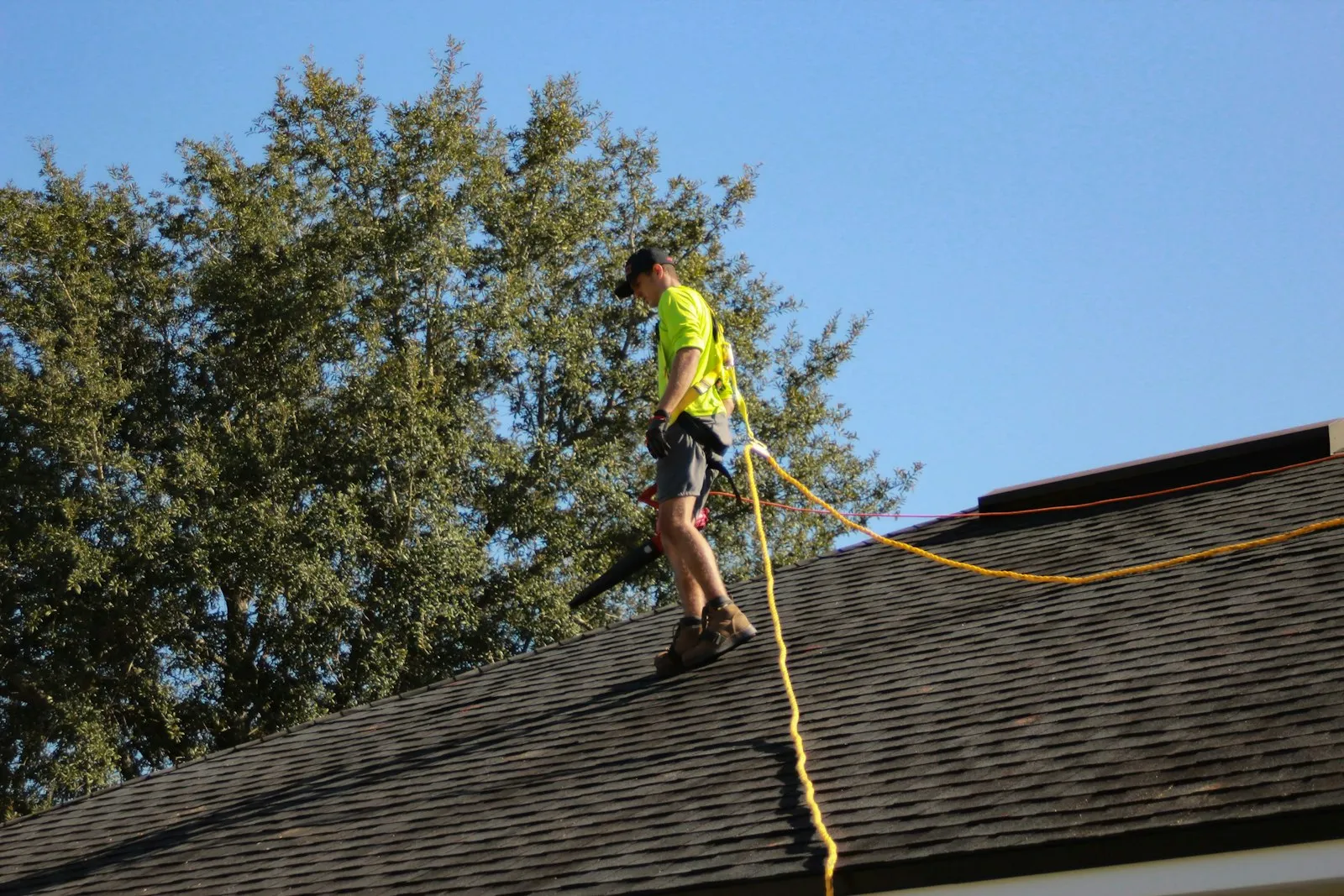 A Shingle & Restoration technician working on a shingle roof