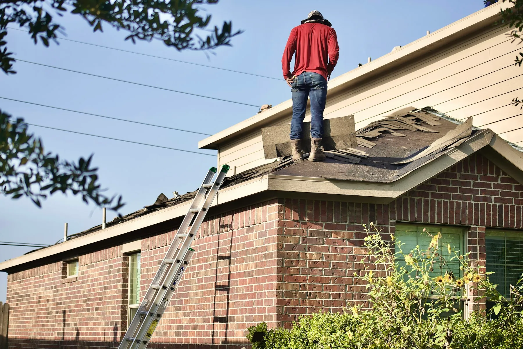 A roofer inspecting and working on a residential roof
